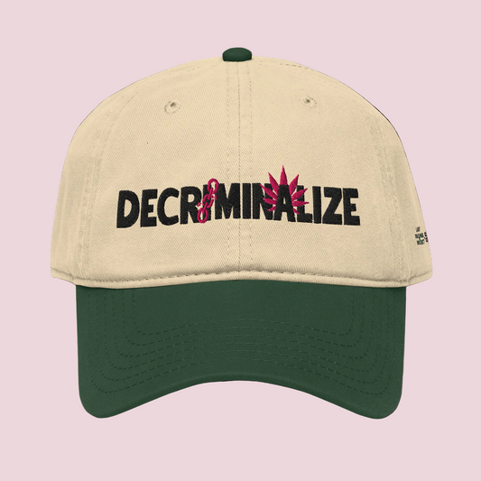 Beige and green cap with 'DECRIMINALIZE' text and cannabis leaf design on a white background