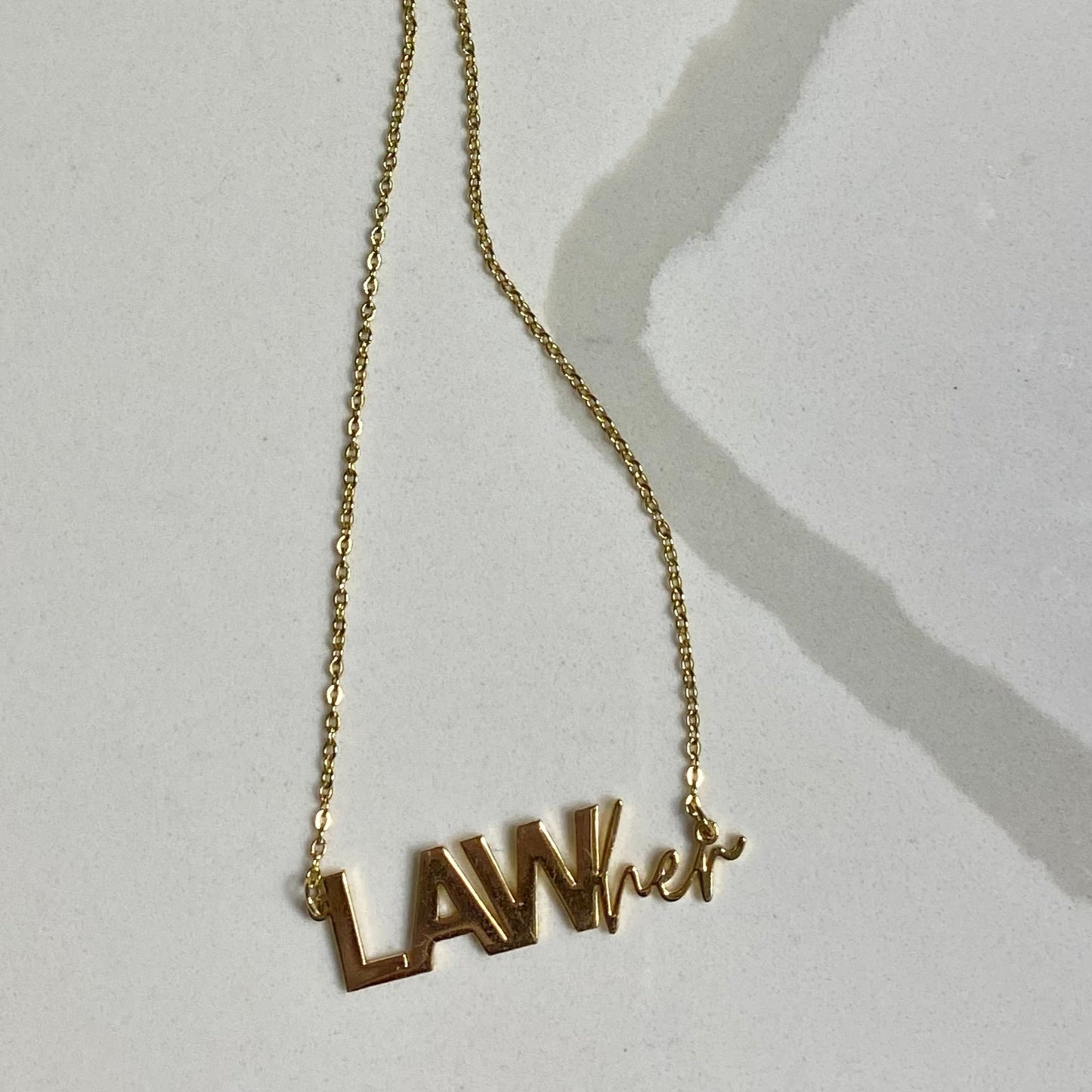 PHOTO OF GOLD NECKLACE WITH THE WORDS "LAWHER"