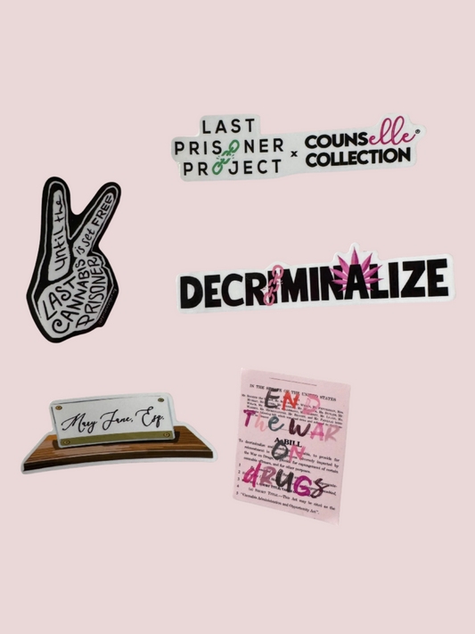 Five stickers showing the following designs: 1. "Last Prisoner Project x Counselle Collection" logos; 2. A hand peace sign, featuring the text "Until the Last Cannabis Prisoner is Set Free"; 3. The text  "DECRIMINALIZE", with a broken pink chain over the first letter "I" and pink cannabis leaves behind the letter "A".; 4. The text "Mary Jane Esq" written on a nameplate; and, 5.  The text "End The War on Drugs" written in different colored font.