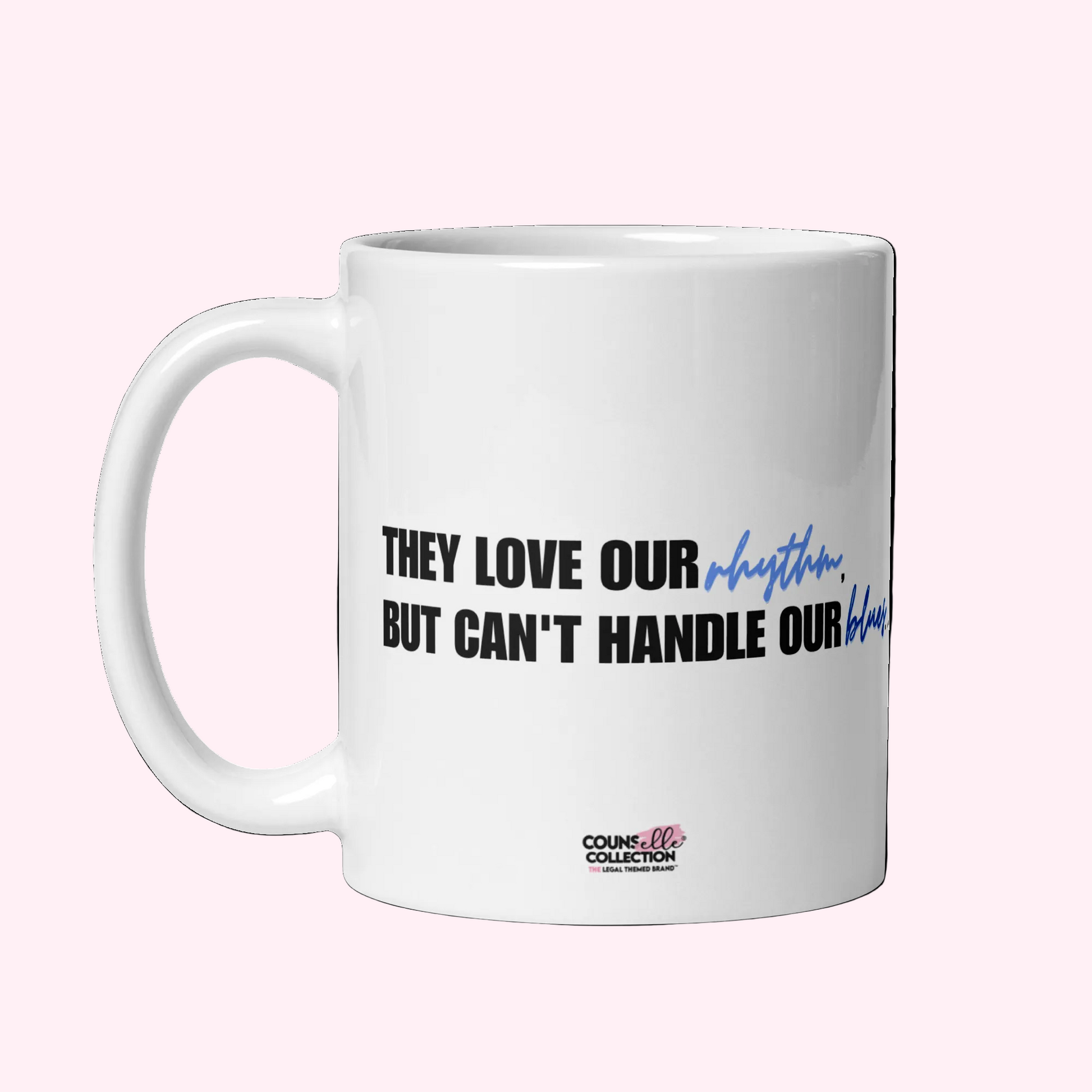 A white, glossy, ceramic mug with the text: they love our rhythm but can't handle our blues. on both sides