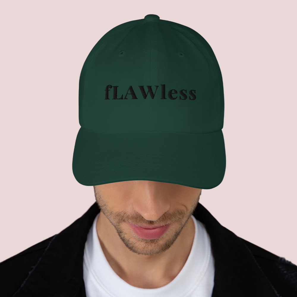 A male model wearing a dark green cap featuring the word "fLAWless" in black font
