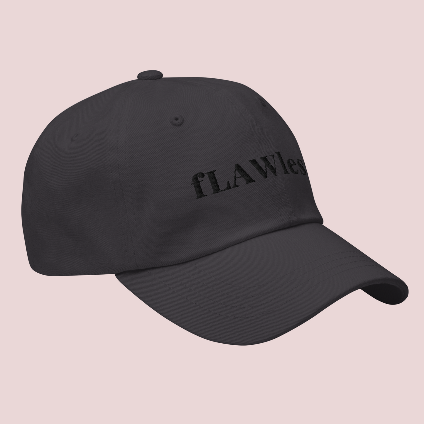 A dark grey cap featuring the word "fLAWless" in black font