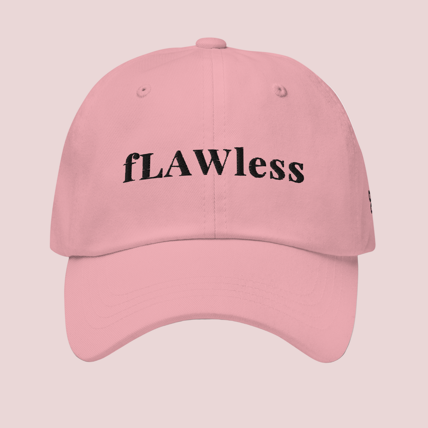 A pink cap featuring the word "fLAWless" in black font
