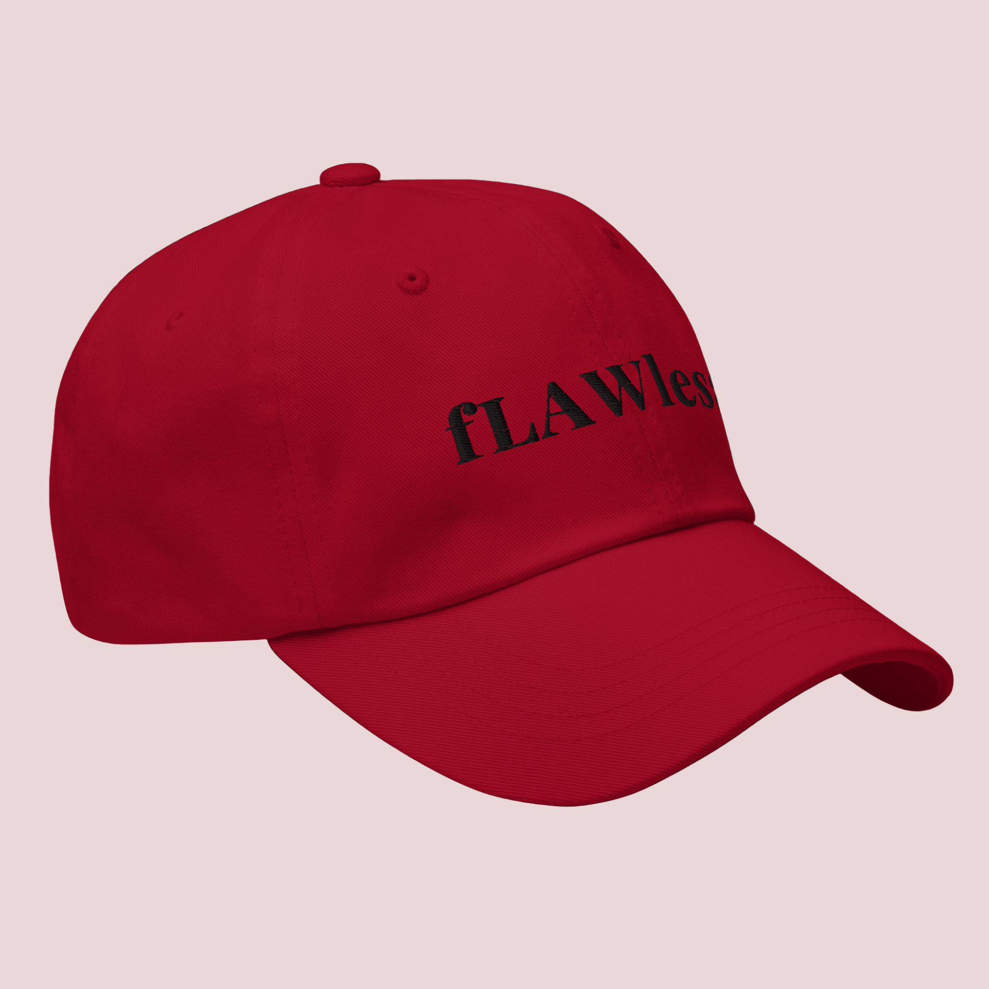 A red cap featuring the word "fLAWless" in black font