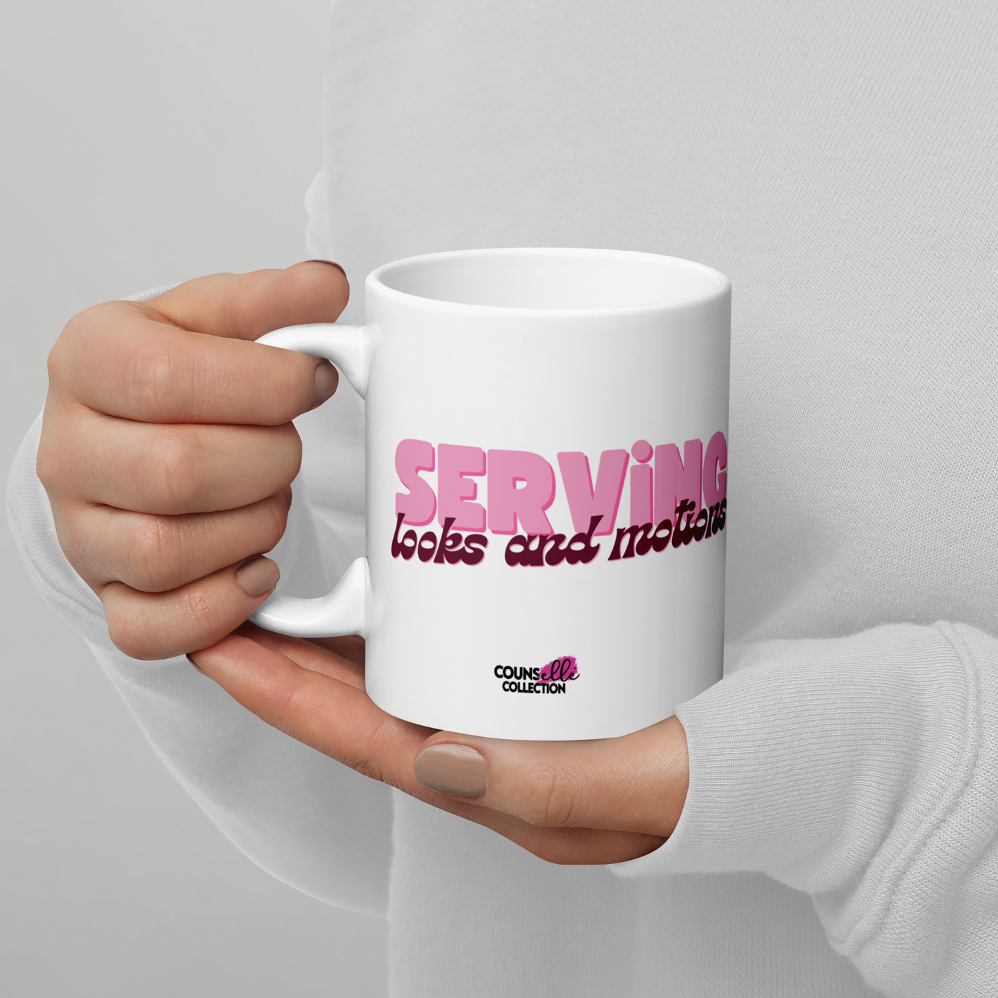 a white, 11oz mug featuring the words "serving looks and motions" in pink and burgundy letters.