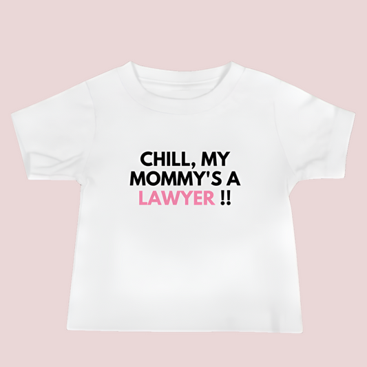 A white roundneck kid's tee featuring the quote "Chill my mommy's a lawyer" in uppercase text.