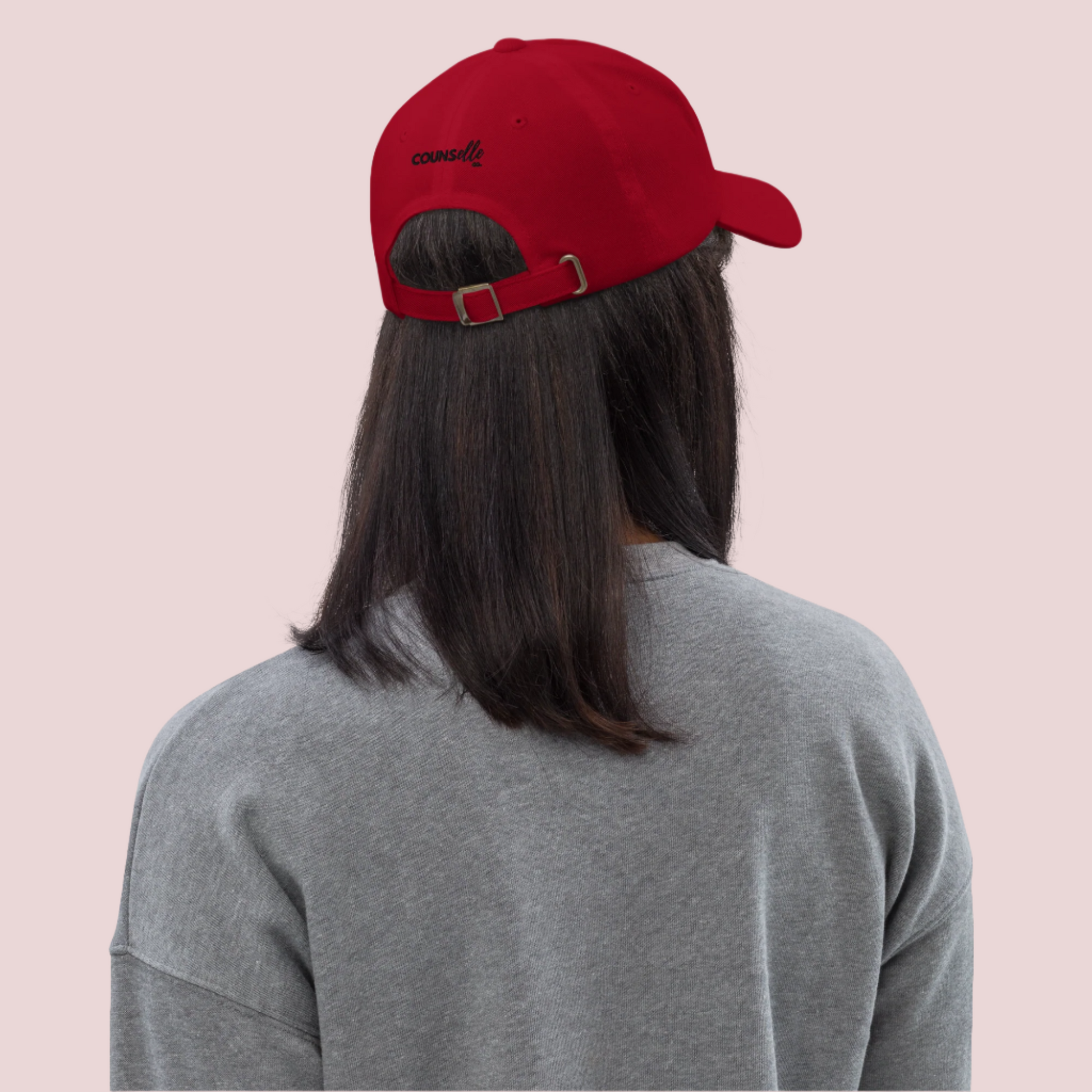 A person wearing a red baseball cap with the counsellecollection logo [back  view].