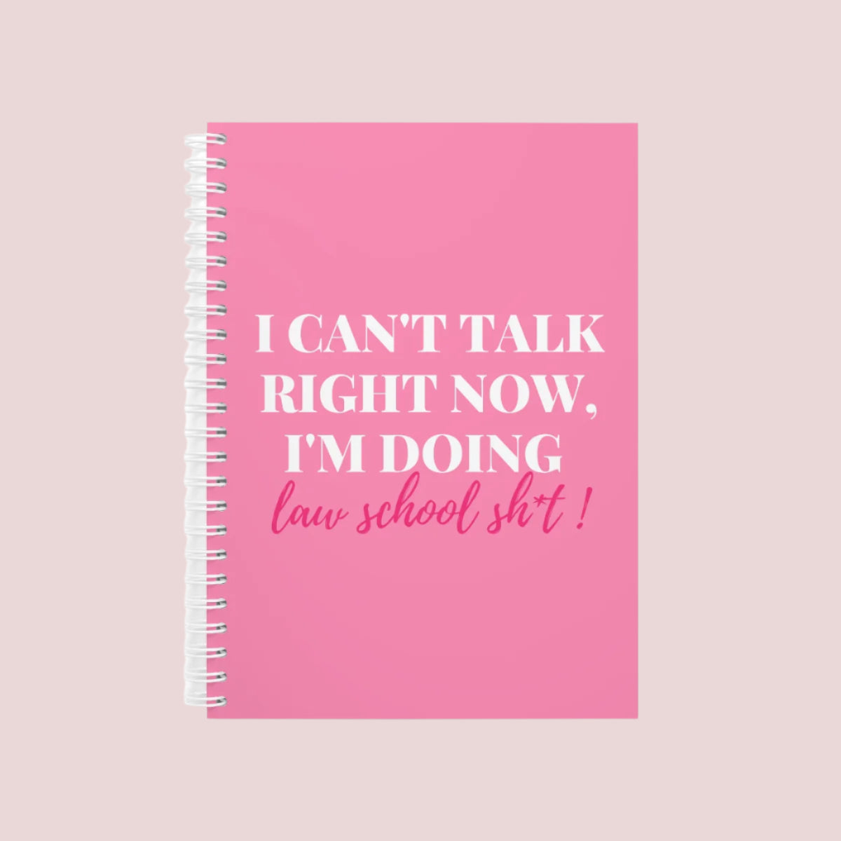 A pink wire bound notebook with the text "I can't talk right now, I'm doing law school sh*t" on the cover.
