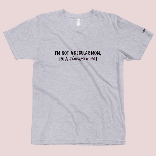 A heather grey round-neck tee with the text "I'M NOT A REGULAR MOM, I'M A #LawyerMom!" in black" text and the counsellecollection logo on the left sleeve.