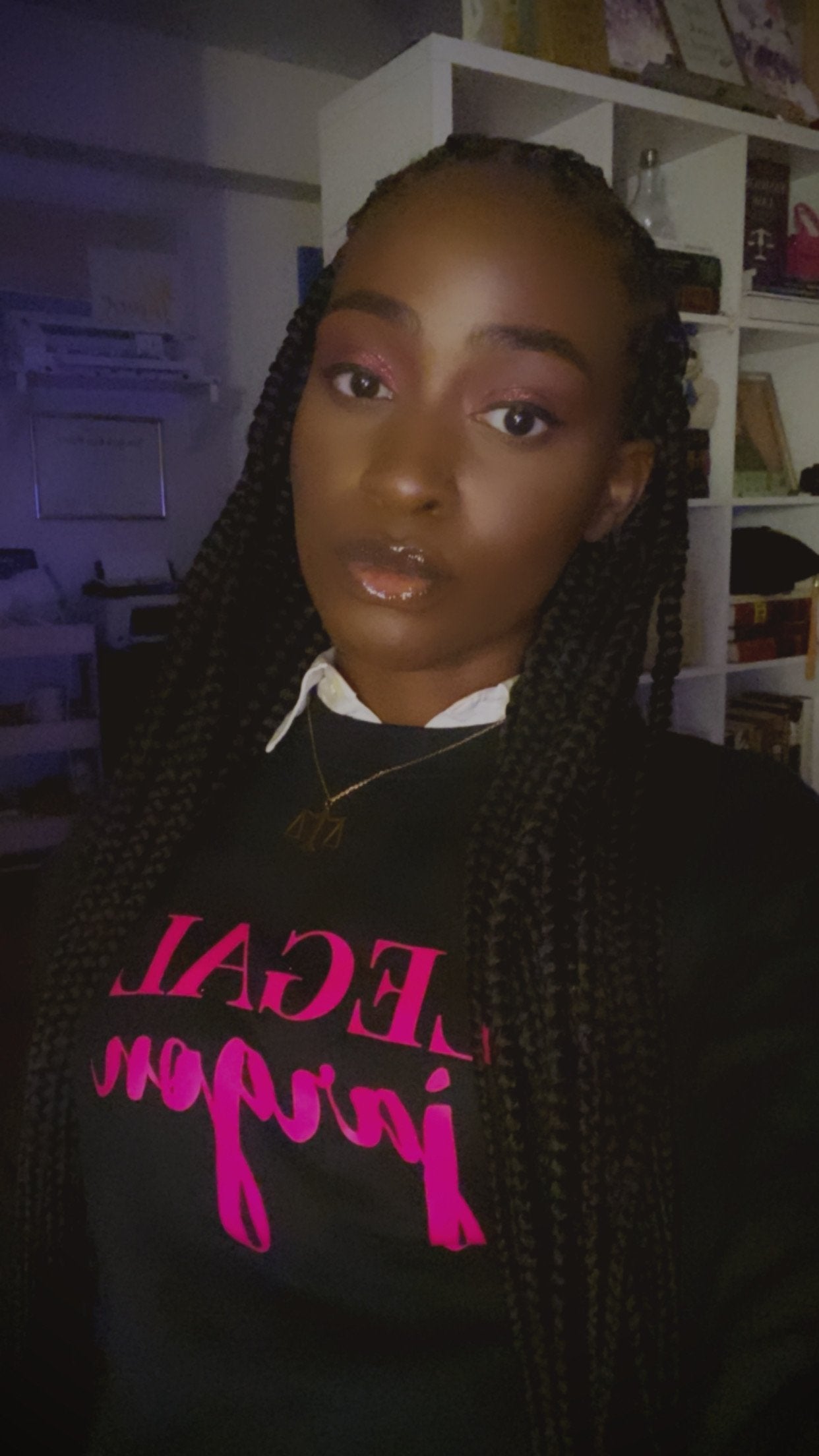 A person wearing a black crewneck, long-sleeved sweatshirt with the text "LEGAL" in pink uppercase letters and "jargon" in pink script font.