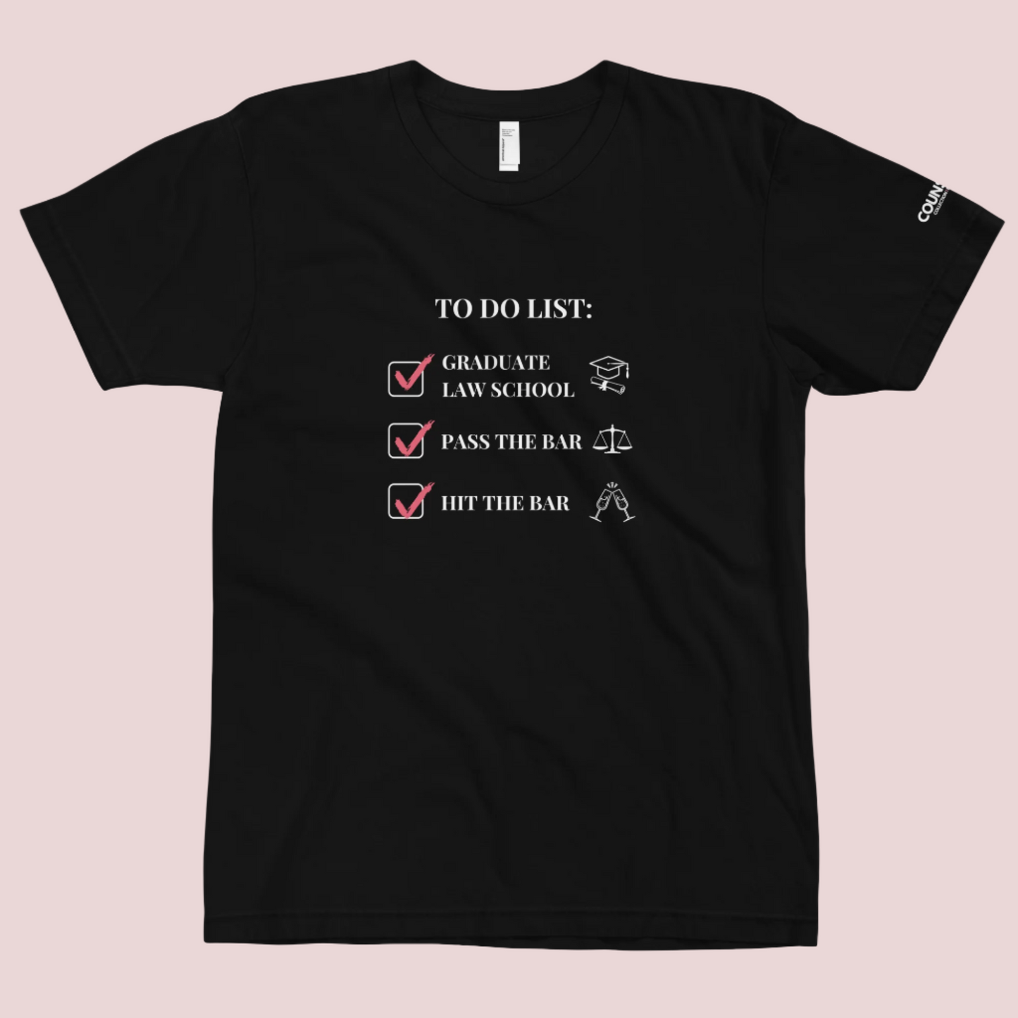 A black crewneck tee showing the text "TO DO LIST", with ticked-off boxes beside the texts "GRADUATE LAW SCHOOL" and an illustration of a graduation cap and diploma; "PASS THE BAR" and an illustration of justice scales; and "HIT THE BAR" and an illustration of clinking champagne flutes, with the counsellecollection logo on the left sleeve.