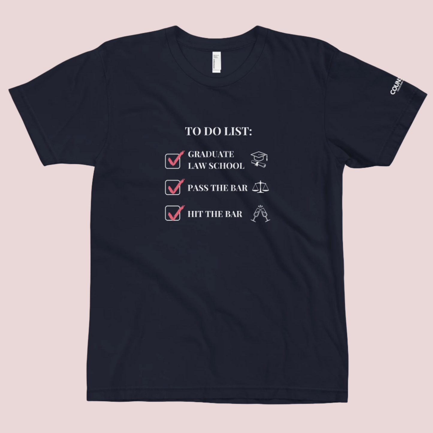 A navy blue crewneck tee showing the text "TO DO LIST", with ticked-off boxes beside the texts "GRADUATE LAW SCHOOL" and an illustration of a graduation cap and diploma; "PASS THE BAR" and an illustration of justice scales; and "HIT THE BAR" and an illustration of clinking champagne flutes, with the counsellecollection logo on the left sleeve.